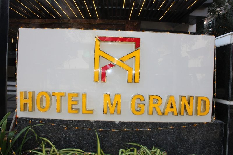 Illuminated Hotel M Grand signboard with the hotel logo