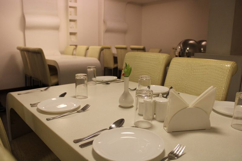 Dining table set with plates, glasses and folded napkins