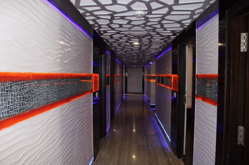 Long corridor with white textured walls and orange accent strips