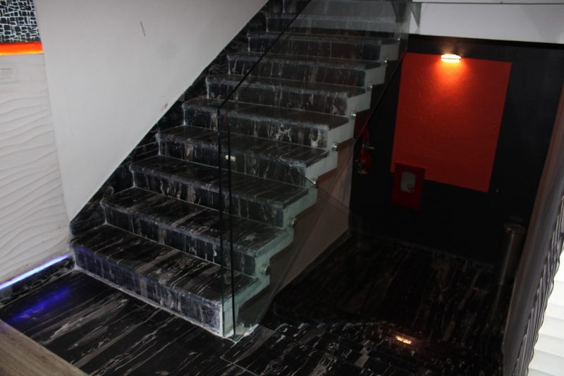 Black marble staircase with a glass railing